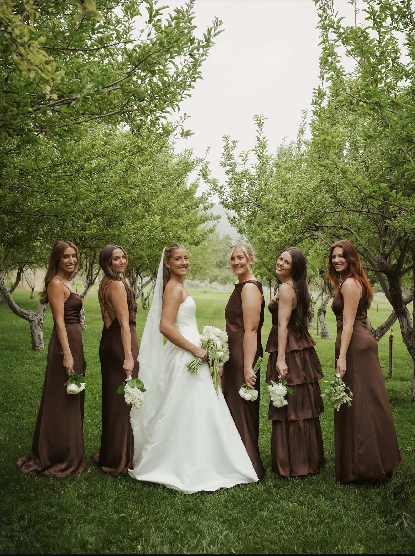 Bride and wedding party in an orchard — makeup by Samantha Kae