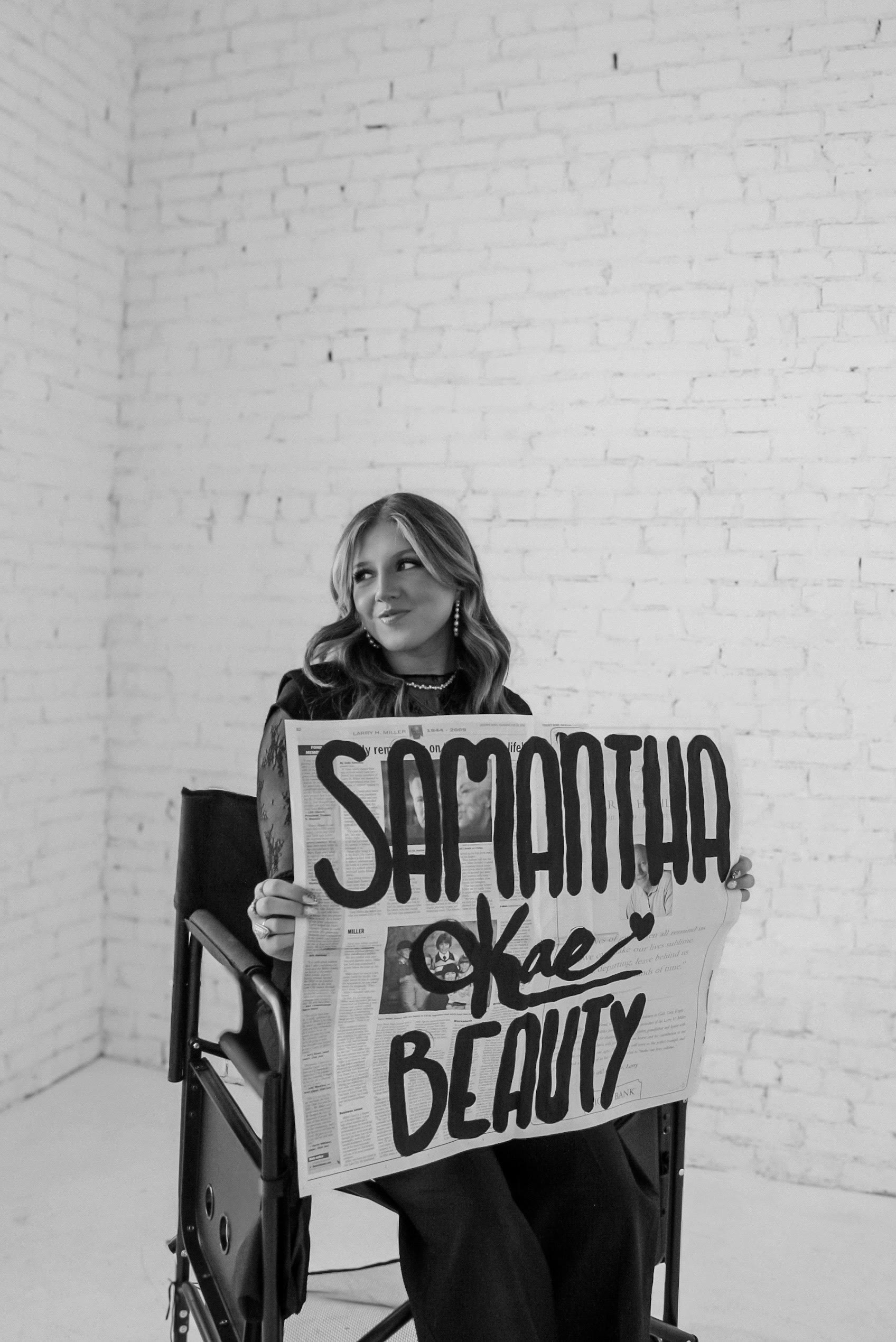 Samantha Kae holding a hand-painted Samantha Kae Beauty newspaper